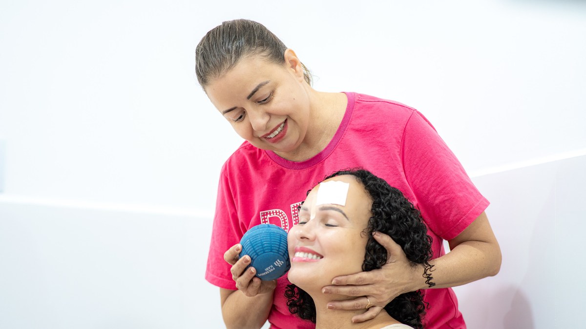 Profissional de saúde faz auriculoterapia em mulher durante o Dia D do Outubro das Rosas no CPCOM, em Boa Vista
